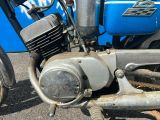 un gros plan d'une vieille moto posée par terre