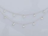 un collier en or blanc orné de cinq diamants sur une chaîne
