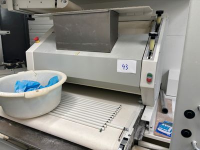 une machine équipée d'un bac placé sur un tapis roulant