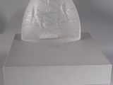 une image représentant une boîte blanche surmontée d'une sculpture en verre