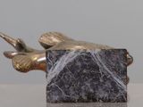a statue of a bird that is sitting on a marble block
