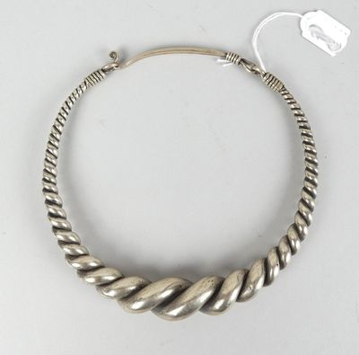 gros plan d'un bracelet en argent sur une surface blanche