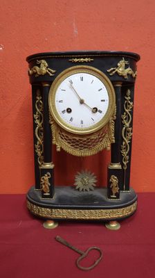a black and gold clock on a red table