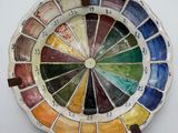a plate with a colorful wheel on it on a white surface