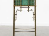 a green glass and brass desk with a shelf on top of it