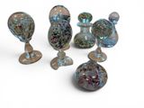 five glass vases sitting next to each other on a white surface
