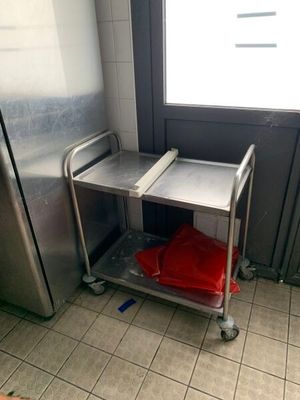 un chariot argenté sur lequel est posé un sac rouge, dans une cuisine