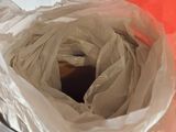 a person holding a plastic bag with a piece of paper in it