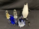 trois pingouins en verre assis les uns à côté des autres sur une table