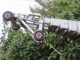 a silver truck that is upside down in the air