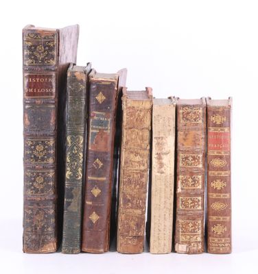 plusieurs vieux livres sont alignés sur une surface blanche