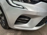 the front end of a silver car with a black bumper
