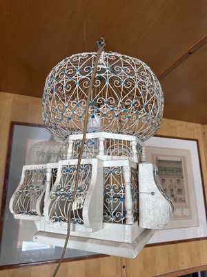 a birdcage hanging from the ceiling in a room