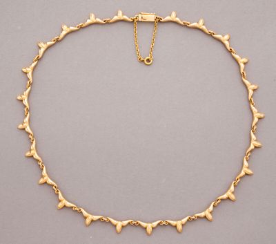 a gold necklace with small hearts on a gold chain