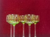 quatre verres à vin posés sur une table devant un mur rouge