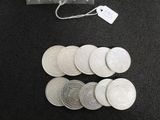 a lot of silver coins on the table next to a bag of money