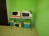 two microwaves sitting on a table in a green room