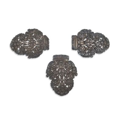 trois pièces métalliques argentées sur une surface blanche, avec un fond blanc