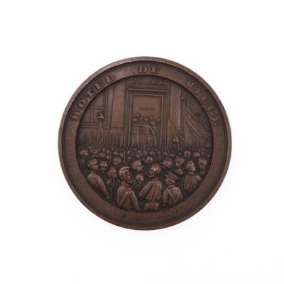 une image représentant une médaille de bronze sur laquelle figure un homme s'adressant à un groupe de personnes