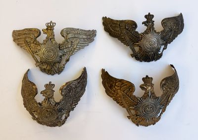 Quatre types différents d'insignes militaires sont présentés sur un fond blanc