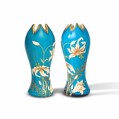 une paire de vases bleus et dorés ornés de fleurs sur fond blanc