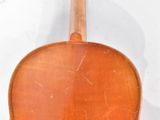 an old violin sitting on top of a white surface