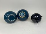 three blue vases with gold rims and a black ball