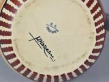 a red and white plate with a black writing on it