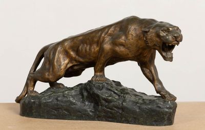 bronze statue of a lion on a rock on a table