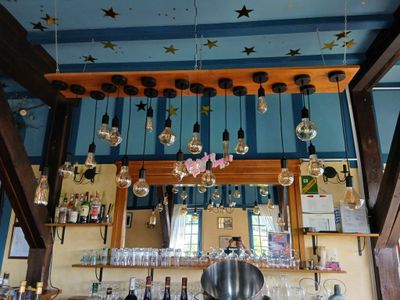 un bar où de nombreuses bouteilles et verres sont suspendus au plafond