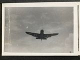 a black and white photo of a plane flying in the sky