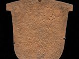 an image of a stone shield on a stand against a black background