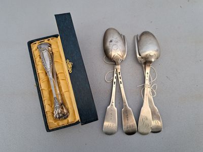 trois cuillères en argent et deux cuillères en argent dans une boîte