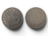 two old silver coins on a white surface with a white background