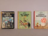 trois livres sont alignés les uns à côté des autres sur une étagère