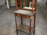 une petite table sur laquelle est posé un miroir, au milieu d'une pièce