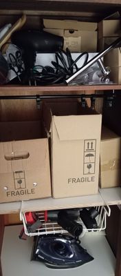 a shelf with boxes and an iron on it