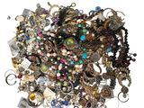 a pile of assorted jewelry on a white surface