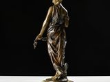 a bronze statue of a woman standing on a marble base