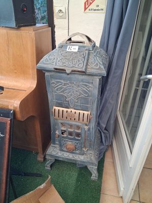 a small stove sitting in the corner of a room next to a piano