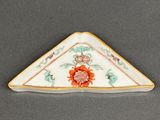un gros plan d'une assiette triangulaire ornée d'un motif floral