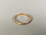 gros plan d'une bague en or sur une surface blanche
