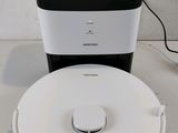 a white and black robot sitting next to a black and white box