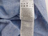 the label on a blue sweater is attached to a white shirt