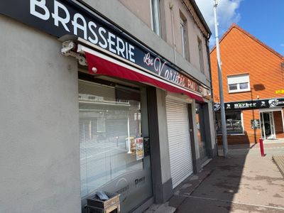 un immeuble avec une enseigne indiquant « brisssiede » et un banc sur le trottoir devant celui-ci