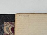 an old book with a black cover and a red and white design