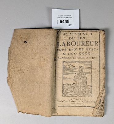 un vieux livre posé sur une table, à côté d'une étiquette