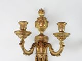 a gold colored candle holder with three candles on it