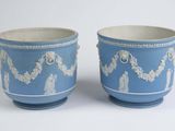 pair of blue and white vases with designs on them on a white surface