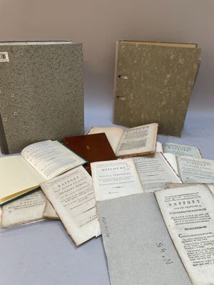plusieurs livres ouverts posés sur une table à côté d'une pile de documents
